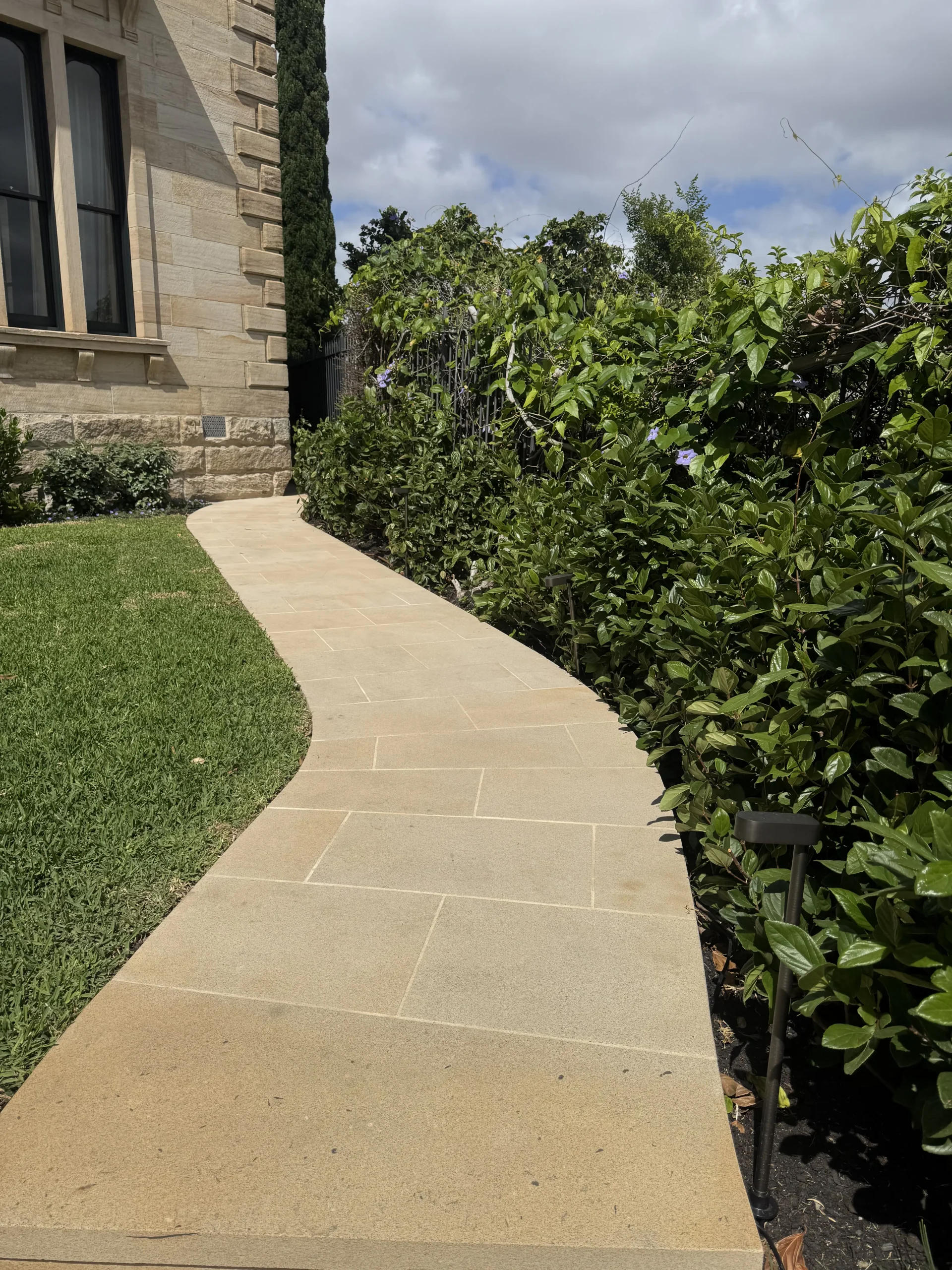Crazy-paved stone wall with a circular feature cut-out and Sydney skyline in the background