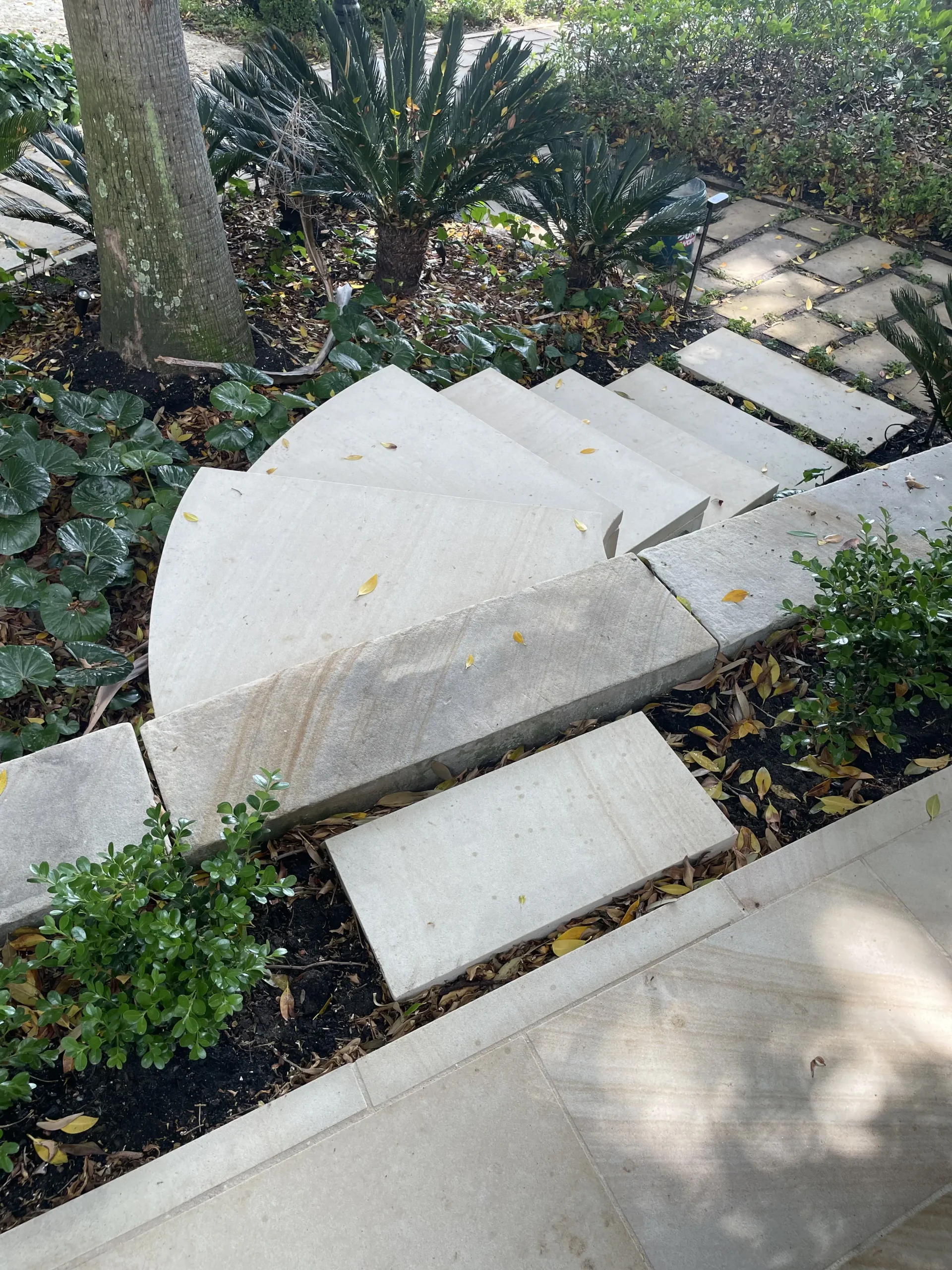 Curved sandstone staircase built into a landscaped garden