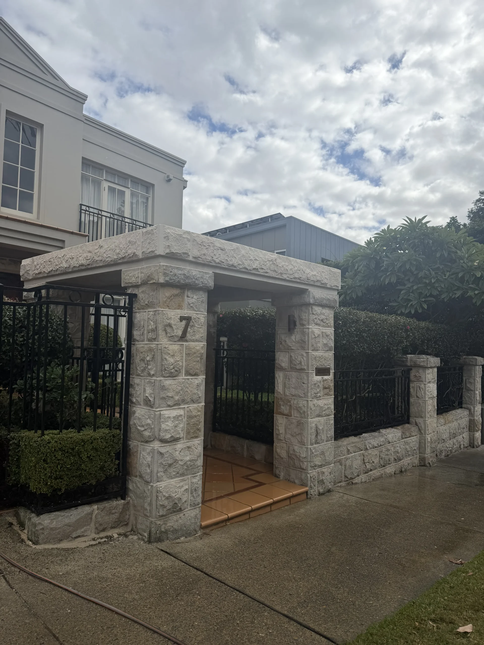 Granite-clad entrance pillars and paved footpath