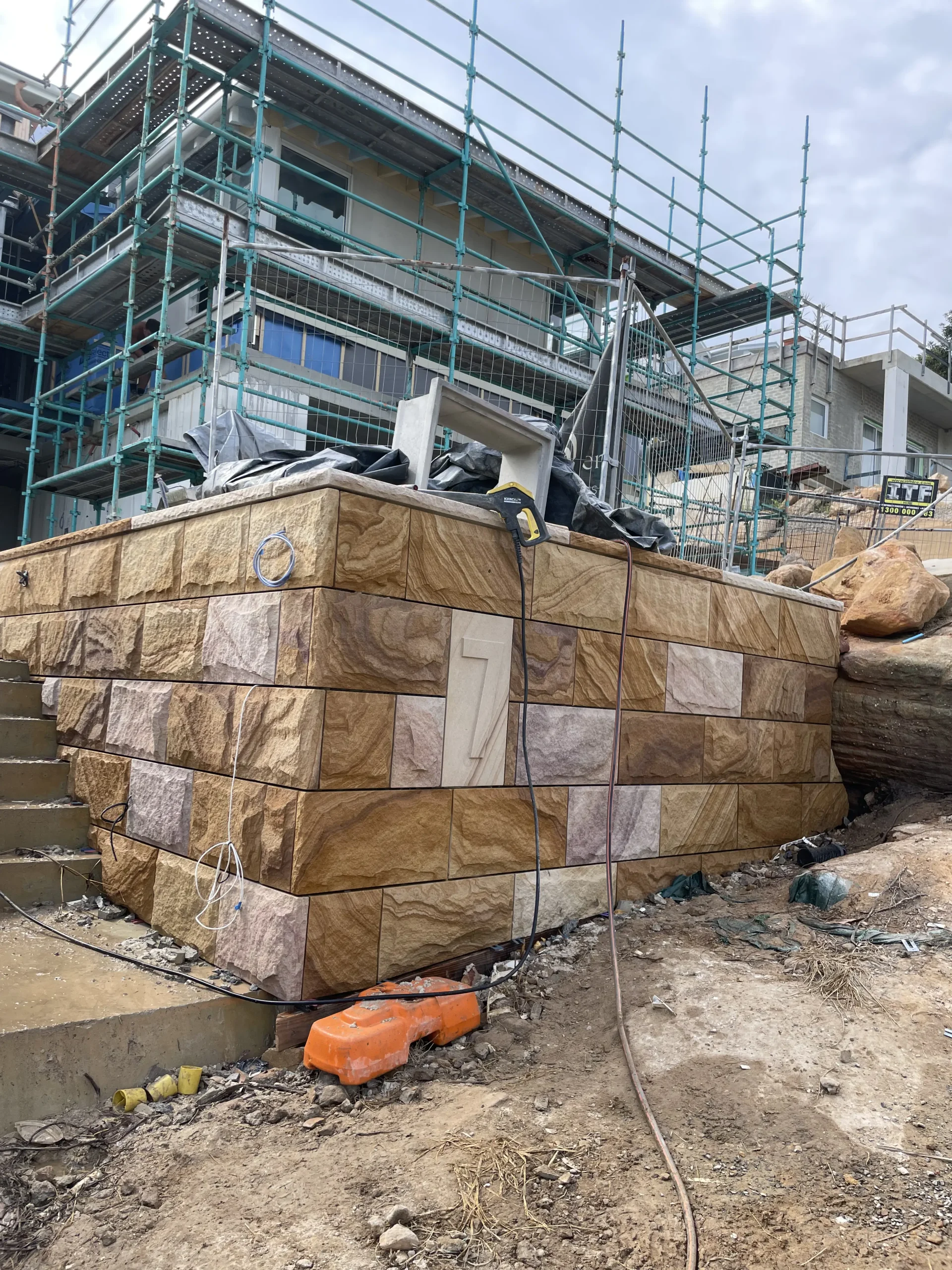 Close-up of a multicolour sandstone-clad pier beside stone steps