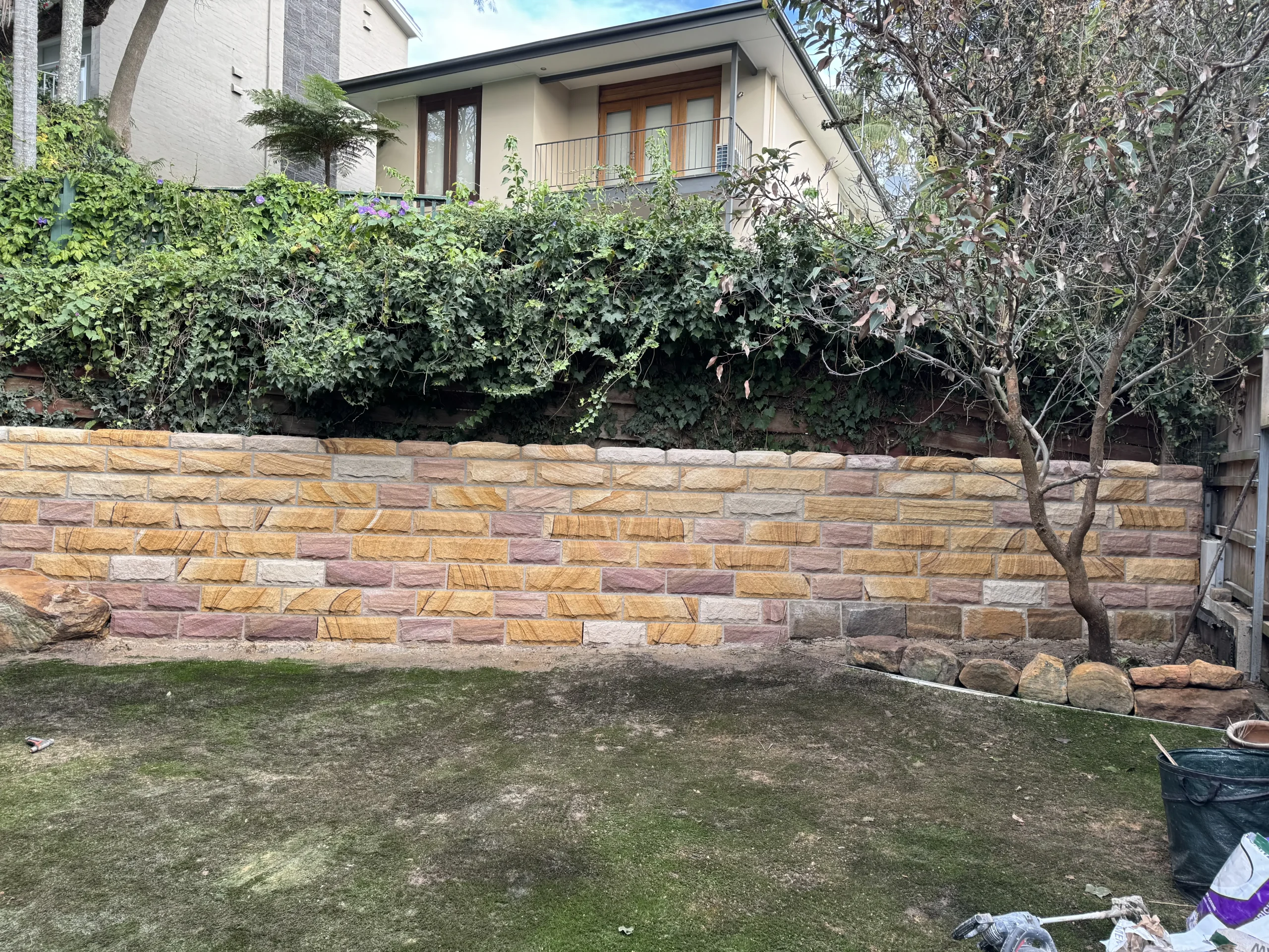 Multicolour sandstone retaining wall in a Sydney backyard