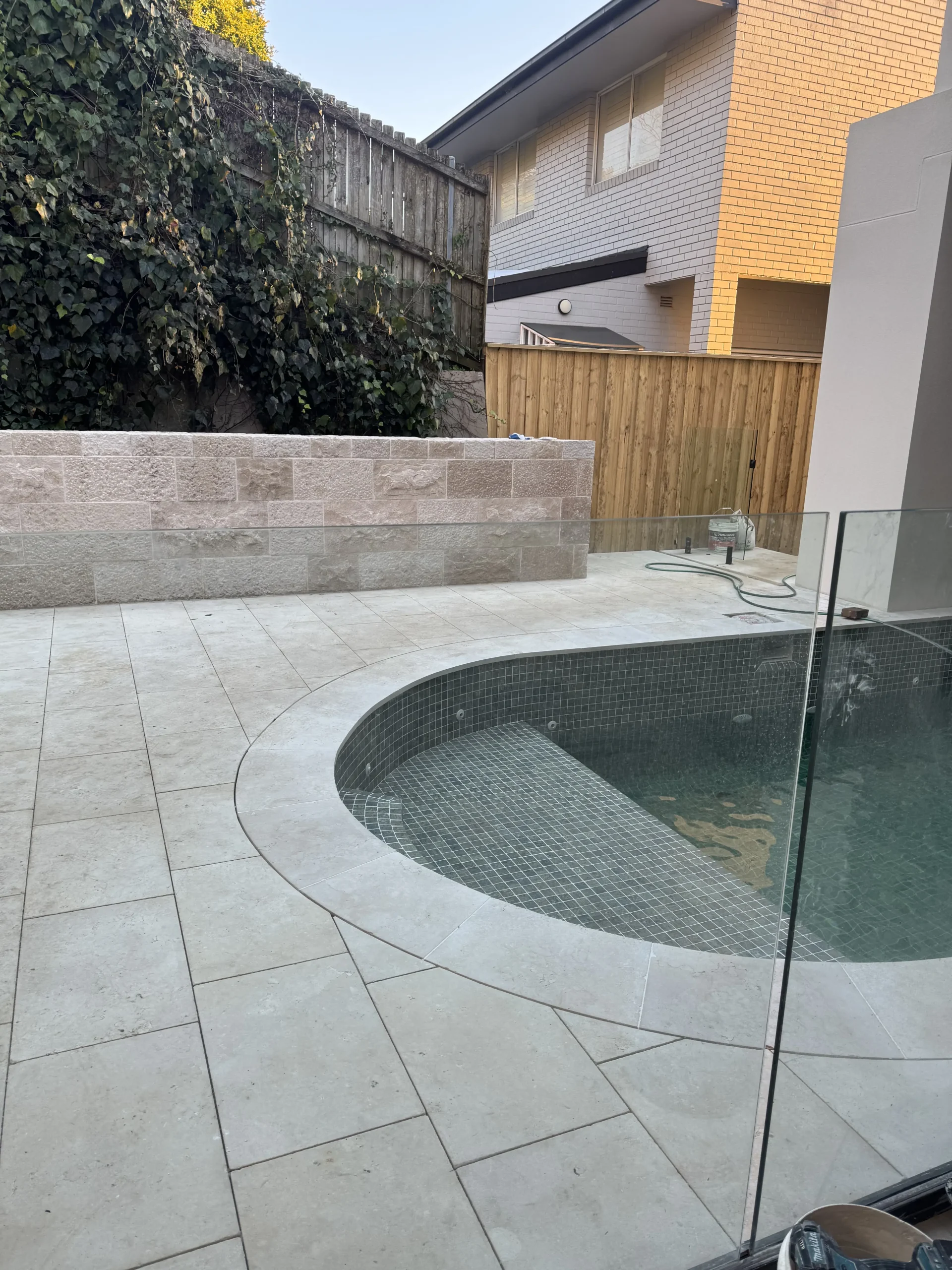 Stone paving and coping around a backyard pool