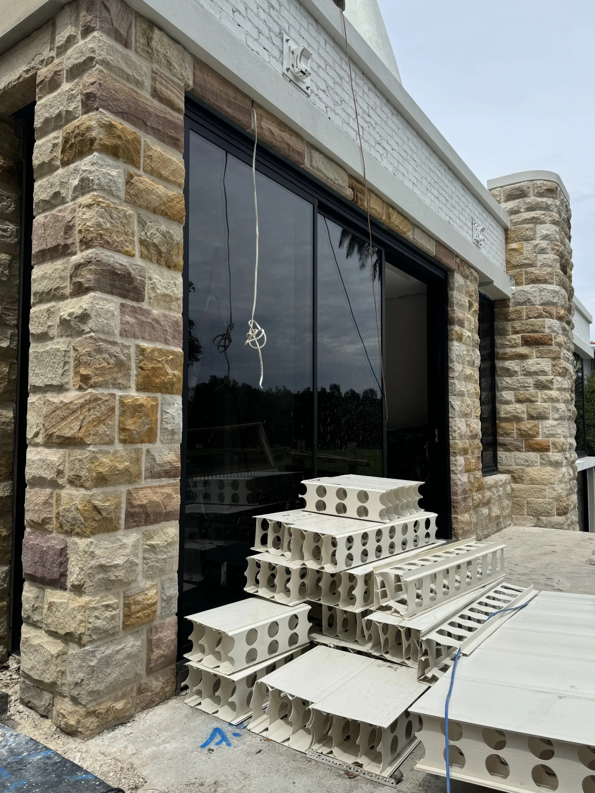 Sandstone-clad pillar beside a glazed doorway