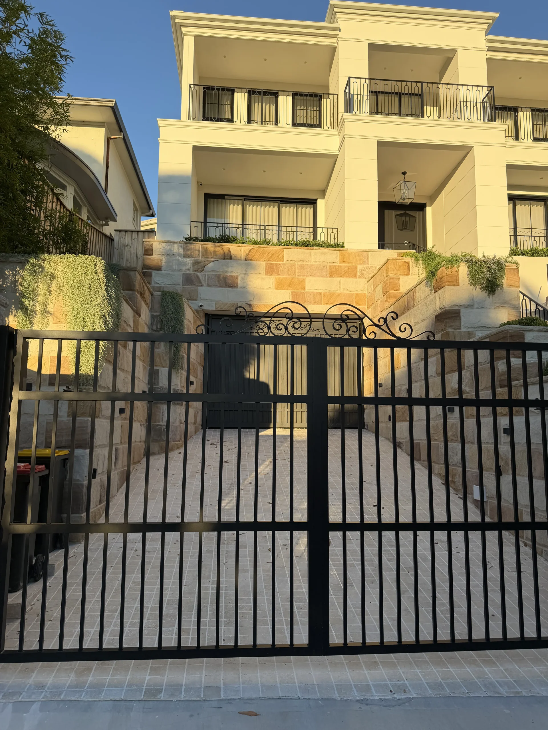 Sandstone entrance pillars and paving at a garden gate