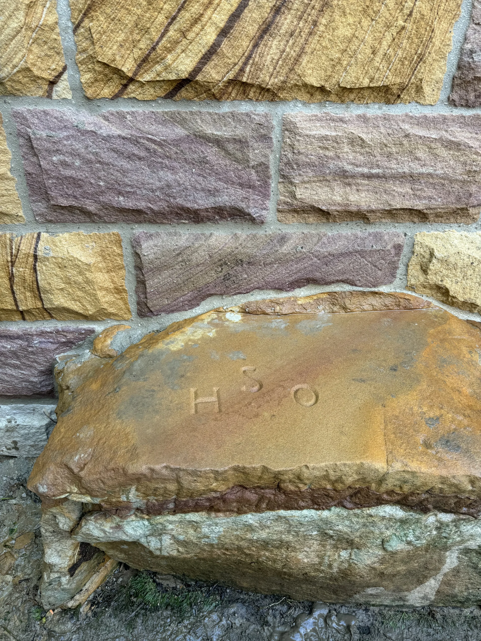 Close-up of a sandstone block showing its original quarry stamp