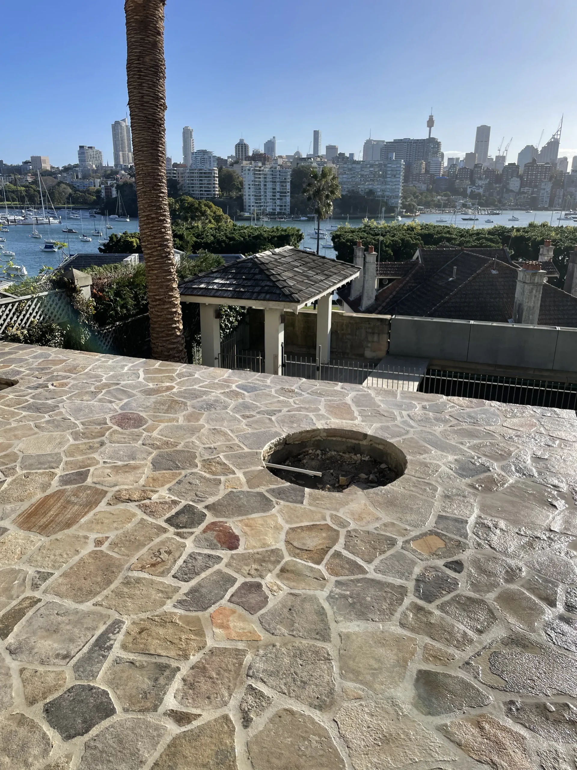 Crazy-paved sandstone terrace overlooking Sydney Harbour and the city skyline